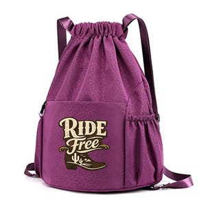 Puede incluir: Mochila morada con cordón y estampado texturizado. El bolsillo delantero presenta las palabras "RIDE FREE" sobre un gráfico de bota de vaquero marrón con una escena desértica. La bolsa tiene correas negras y cierre de cordón.