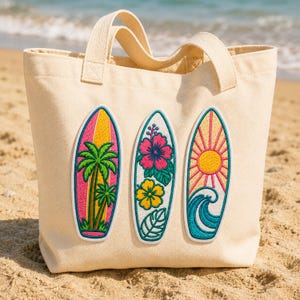 Può includere: Una borsa tote in tela color crema con tre toppe ricamate a forma di tavola da surf. La toppa a sinistra mostra palme, quella centrale fiori di ibisco e quella a destra raffigura un sole che sorge sopra un'onda oceanica blu.