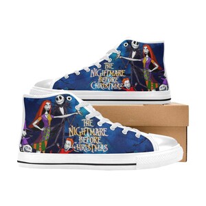 May include: High-top sneakers featuring a blue background with a graphic print of characters from The Nightmare Before Christmas, including Jack Skellington and Sally. The shoes have white laces, white rubber toe caps, and white rubber soles.