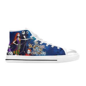 May include: A high-top sneaker featuring a blue canvas upper with a graphic print of characters from The Nightmare Before Christmas, including Jack Skellington and Sally. The shoe has white laces, a white rubber toe cap, and a white rubber sole.