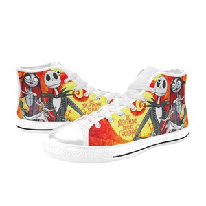 May include: High-top sneakers featuring a vibrant yellow and red graphic print of Jack Skellington, Sally, and Zero from The Nightmare Before Christmas. The shoes have white laces, white rubber toe caps, and white soles with a black stripe detail.