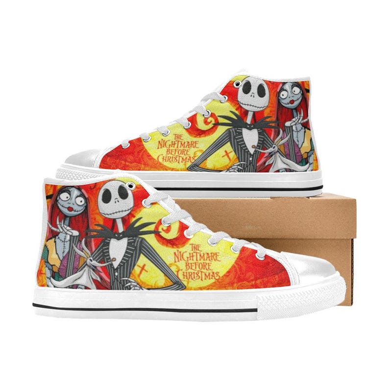 May include: High-top sneakers featuring a vibrant orange and yellow background with a graphic print of Jack Skellington, Sally, and Zero from The Nightmare Before Christmas. The shoes have white laces, white rubber toe caps, and white soles.