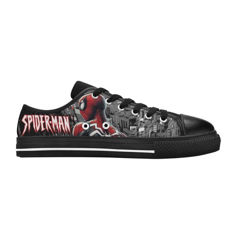 May include: Black low-top canvas sneakers featuring a Spider-Man design. The sneakers have a black rubber sole and laces. The Spider-Man graphic is in red and black, with the words "SPIDER-MAN" in red on the side.
