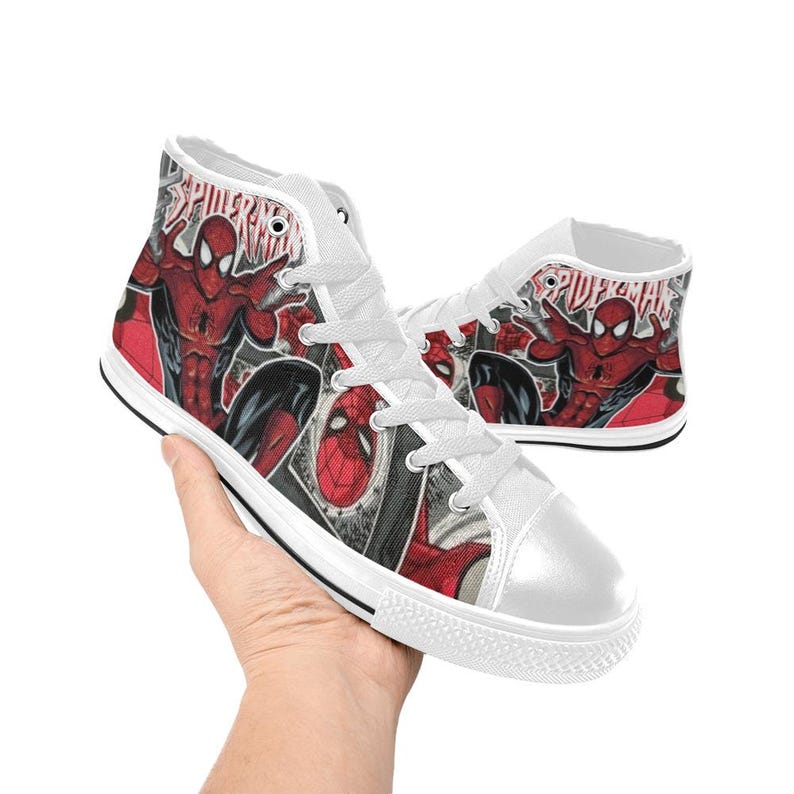 May include: High-top canvas sneakers featuring a red and black Spider-Man graphic print with the text Spider-Man. The shoes have white laces, white eyelets, a white rubber toe cap, and a white rubber sole with a thin black stripe along the edge.