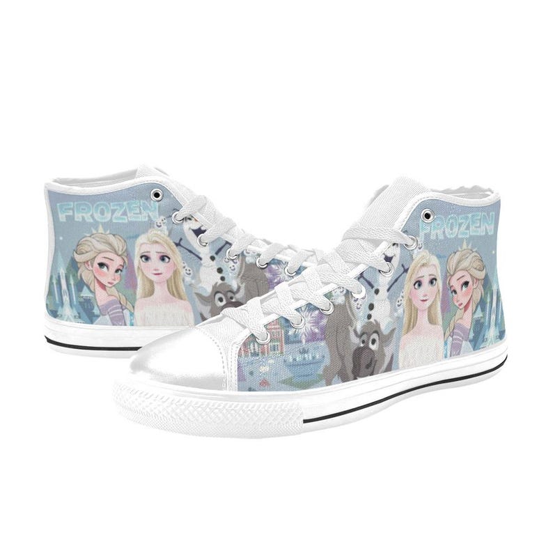 Pode incluir: Um par de t&eacute;nis de cano alto em lona branca com uma impress&atilde;o gr&aacute;fica azul-clara de personagens do filme Frozen, incluindo Elsa, Anna, Olaf e Sven. Os sapatos t&ecirc;m atacadores brancos, biqueiras de borracha branca e a palavra Frozen.