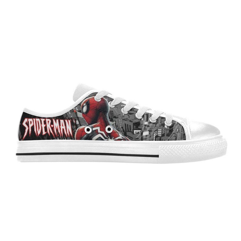 May include: White canvas sneakers featuring a Spider-Man design. The side of the shoe displays the Spider-Man logo in red and black, with an image of Spider-Man. The background has a cityscape design.