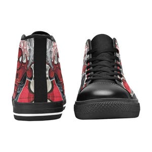 May include: A pair of high-top sneakers featuring a red and black Spider-Man comic book graphic print. The shoes have black laces, black toe caps, and black soles with a thin white stripe. The design includes the Spider-Man logo and character.