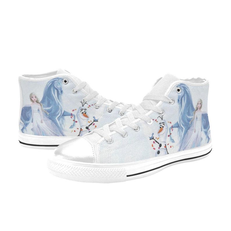 Pu&ograve; includere: Un paio di scarpe alte in tela bianca con una stampa raffigurante un personaggio biondo in abito lungo, un cavallo blu e un pupazzo di neve. Le scarpe presentano lacci bianchi, punte in gomma bianca e un bordo nero lungo le suole.