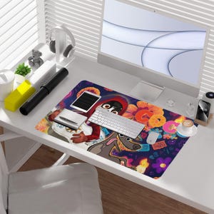 May include: A colorful desk mat featuring a vibrant design with cartoon characters, flowers, and the word "Coco". The mat includes a keyboard, mouse, tablet, and a cup of coffee, creating a lively workspace.