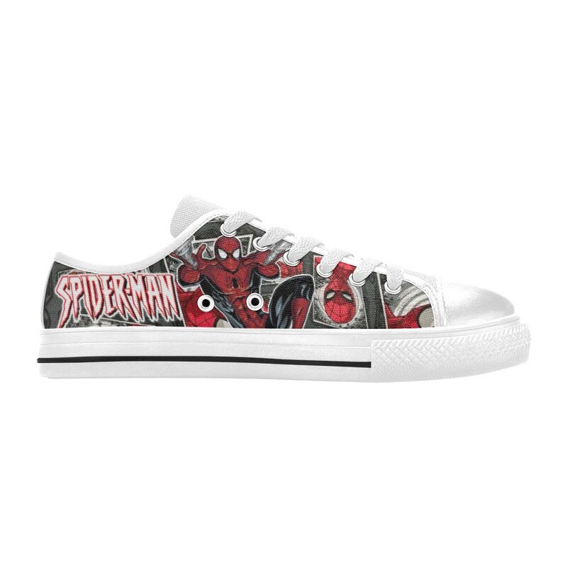 May include: A low-top sneaker featuring a white rubber sole and white laces. The canvas upper displays a comic book graphic of Spider-Man in red and blue, with the text SPIDER-MAN printed in a stylized red font against a black and white background.