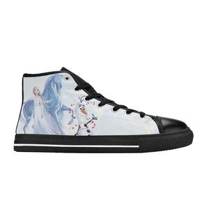 Pu&ograve; includere: Una scarpa alta con tomaia in tela bianca caratterizzata da una stampa grafica di un personaggio biondo in abito bianco, un cavallo blu e un pupazzo di neve. La scarpa presenta lacci neri, punta nera e suola nera con una striscia bianca.