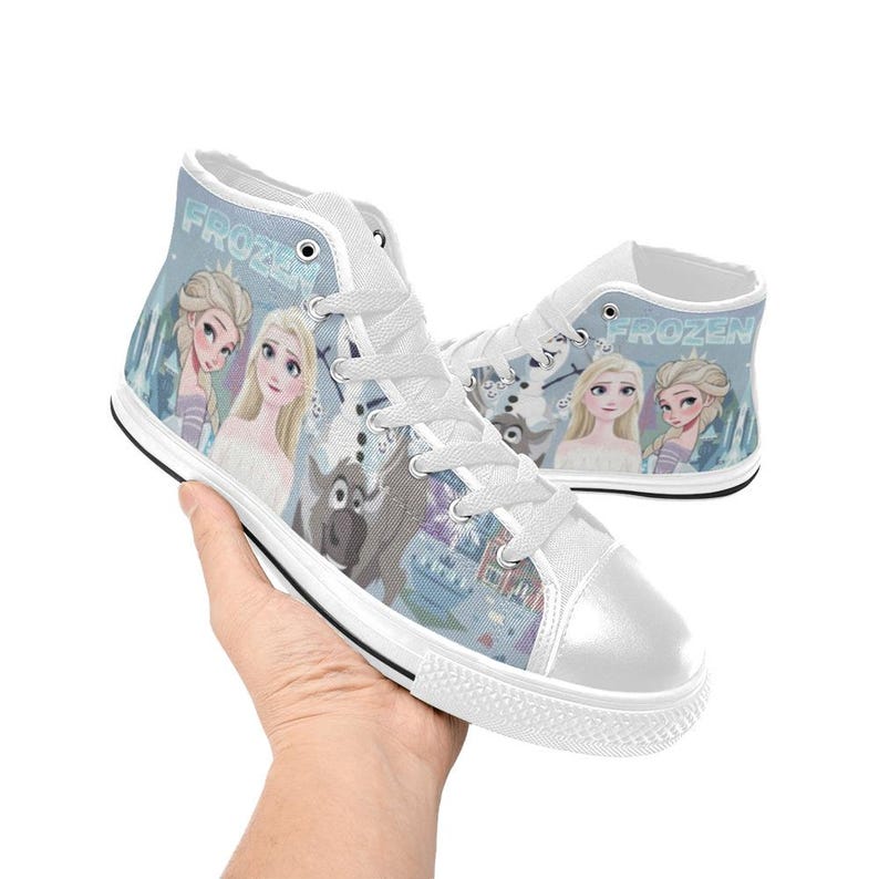 Pode incluir: T&ecirc;nis de cano alto com tema Frozen em azul claro e branco, com estampas de Elsa, Anna e Olaf. Os cal&ccedil;ados possuem cadar&ccedil;os brancos, biqueira de borracha branca e a palavra Frozen impressa em uma fonte estilizada nas laterais.