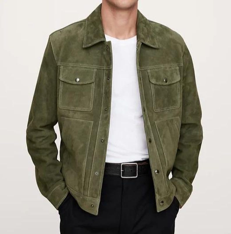 Puede incluir: Chaqueta de ante verde oliva con dos bolsillos en el pecho y cierre de botones. La chaqueta tiene un cuello cl&aacute;sico y se combina con una camiseta blanca, pantalones negros y un cintur&oacute;n negro.