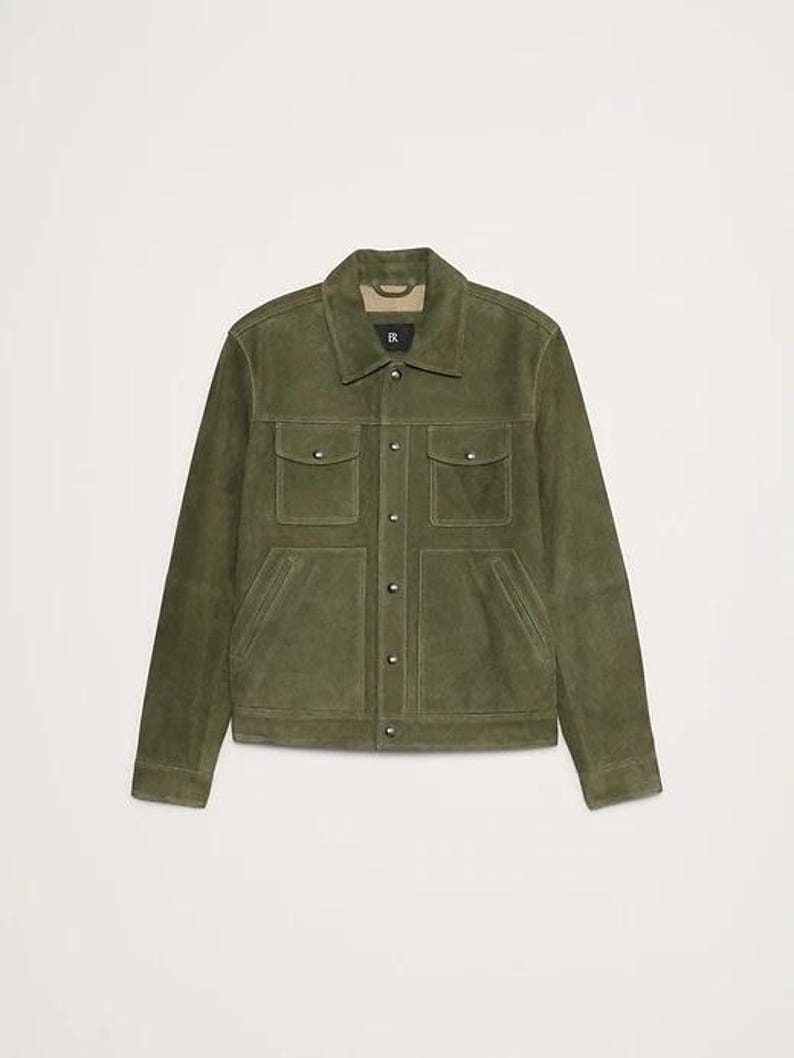 Puede incluir: Chaqueta de ante verde oliva con cuello cl&aacute;sico y cuatro bolsillos delanteros. La chaqueta tiene cierre de botones y mangas largas. La prenda es de color liso y tiene un corte entallado. Una elegante opci&oacute;n de abrigo.
