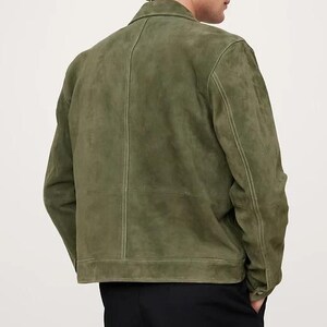 Puede incluir: Chaqueta de ante verde oliva con cuello cl&aacute;sico y cierre de botones. La chaqueta presenta costuras visibles y un corte entallado. La vista trasera muestra el dise&ntilde;o y la confecci&oacute;n.