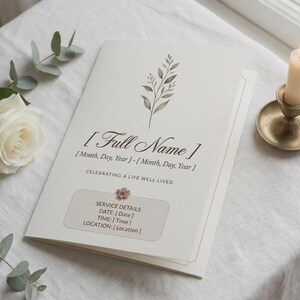 May include: A cream-colored memorial program with the text "[Full Name]" and "Celebrating a Life Well Lived." The program includes space for service details and is decorated with a floral sprig. A lit candle in a brass holder and a white rose are also present.