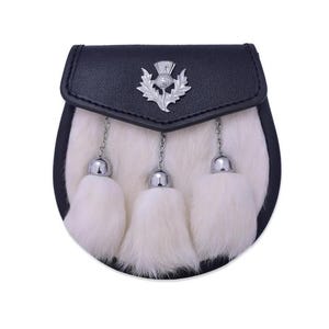May include: A black leather sporran featuring a white fur front panel and three white fur tassels suspended by silver-toned chains. The top flap is adorned with a central silver-toned metal thistle emblem, providing a distinct decorative detail.