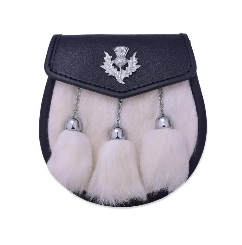 May include: A black leather sporran featuring a white fur front panel and three white fur tassels suspended by silver-toned chains. The top flap is adorned with a central silver-toned metal thistle emblem, providing a distinct decorative detail.