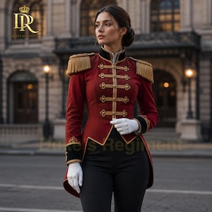 May include: A deep red military-style jacket featuring gold braided trim, decorative gold buttons, and gold fringe epaulets on the shoulders. The jacket has a high black collar, black cuffs, and is worn with white gloves and black trousers.