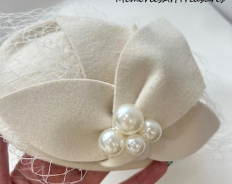 Tocado vintage de fieltro color marfil con racimo de perlas y red tipo jaula, elegante tocado nupcial.