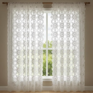 May include: White lace curtains with a floral pattern hang in front of a window. The curtains are made of a delicate, open-weave fabric, allowing light to filter through. The curtains are hung on a wooden rod.
