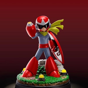 Puede incluir: Figura de un personaje con traje rojo y gris, con casco, visera y botas rojas. El personaje sostiene un cañón rojo y un escudo con una D blanca. La figura se encuentra sobre una base con hierba, rocas y luces amarillas.