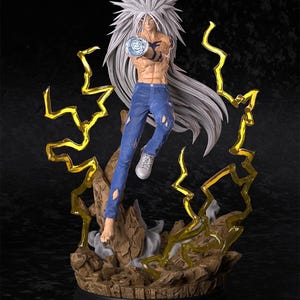 Puede incluir: Figura detallada de un personaje con pelo blanco puntiagudo, vaqueros azules y torso musculoso. La figura posa con un orbe azul brillante en una mano, rodeada de rayos amarillos y una base rocosa. La figura está sobre una base negra.