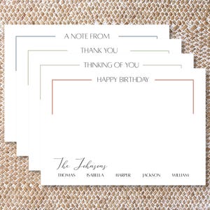 May include: A stack of white rectangular stationery cards featuring minimalist corner borders in various colors. The cards display the text A NOTE FROM, THANK YOU, THINKING OF YOU, and HAPPY BIRTHDAY, with the name The Johnsons and five names below.