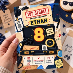 May include: A rectangular birthday invitation card featuring a spy theme with a black briefcase, a large yellow number 8, and the text TOP SECRET, MISSION: CELEBRATE ETHAN, ETHAN IS TURNING, and details for Saturday August 20, 3:00 PM to 5:00 PM.