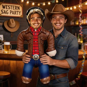 Könnte beinhalten: Ein Mann hält eine Plüschpuppe in Cowboy-Kleidung. Die Puppe hat eine braune Lederjacke, ein rot kariertes Hemd, blaue Jeans und eine silberne Gürtelschnalle. Im Hintergrund ist eine Bar mit einem "WESTERN SAG PARTY" Schild zu sehen.