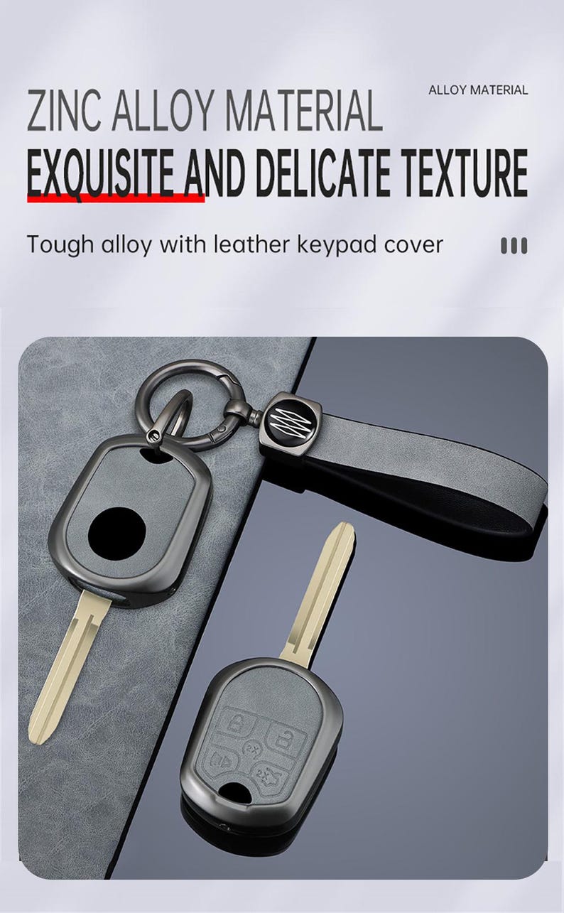 May include: A set of car keys with a zinc alloy key fob and a leather strap. The key fob is dark gray with a black button and a silver key ring. The text "ZINC ALLOY MATERIAL EXQUISITE AND DELICATE TEXTURE" is visible.