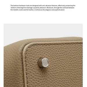 May include: A close-up of a beige leather bag with a silver rivet. The rivet is circular with a textured surface. The bag has visible stitching along the edges. The text "Bottom rivet process" is at the top.
