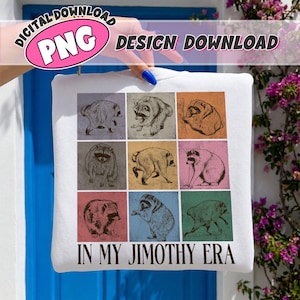 Pode incluir: Uma camisola branca com uma grelha de nove painéis quadrados, cada um contendo um esboço diferente de um guaxinim em várias poses. O texto "IN MY JIMOTHY ERA" está impresso em letras maiúsculas pretas na parte inferior do design.