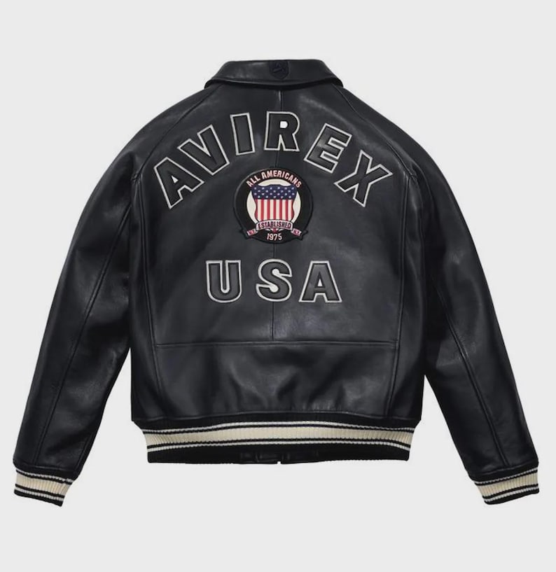 Men’s black leather bomber jacket with front zip closure, ribbed cuffs, striped hem, and USA shield chest patch.