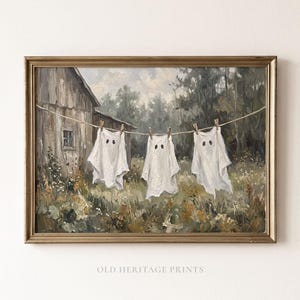 May include: A framed oil painting print featuring three white ghost figures hanging on a clothesline in front of a rustic wooden barn and overgrown field. The artwork displays a muted colour palette of browns, greens, and whites with the text OLD HERITAGE PRINTS at the bottom.