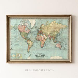 May include: A framed vintage world map print titled Bartholomew's Chart The World, featuring muted pastel colours for continents against a light blue ocean background, with detailed shipping routes and geographical labels in a thin metallic frame.
