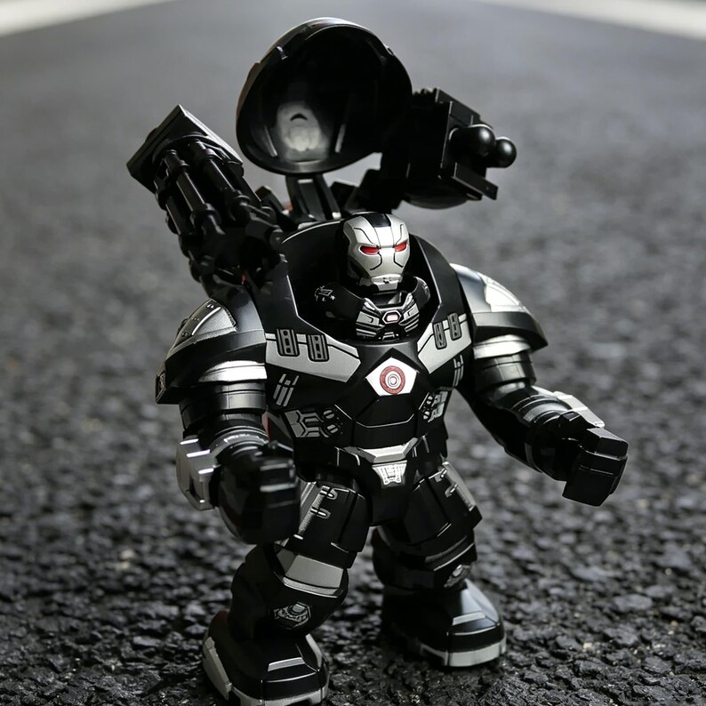 Puede incluir: Una figura de acci&oacute;n negra y plateada de un personaje con forma de robot con un arma grande en la espalda. La figura tiene ojos rojos y un emblema circular en el pecho. La figura est&aacute; sobre una superficie gris oscura.