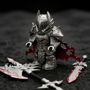 Puede incluir: Una figura de caballero plateado con armadura detallada, casco y capa roja. La figura está acompañada de un hacha y una espada plateadas con detalles rojos. El diseño general tiene un tema de fantasía.