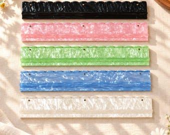 May include: Five rectangular wall-mounted display shelves made of marbled acrylic in black, pink, green, blue, and white. Each shelf features a scalloped top edge, a flat base, and three small circular mounting holes along the upper section.
