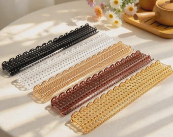 May include: Five long, rectangular, semi-circular arched trays arranged diagonally. Each tray features a perforated mesh pattern and a scalloped edge. The trays are colored in black, clear, light brown, dark brown, and amber yellow.