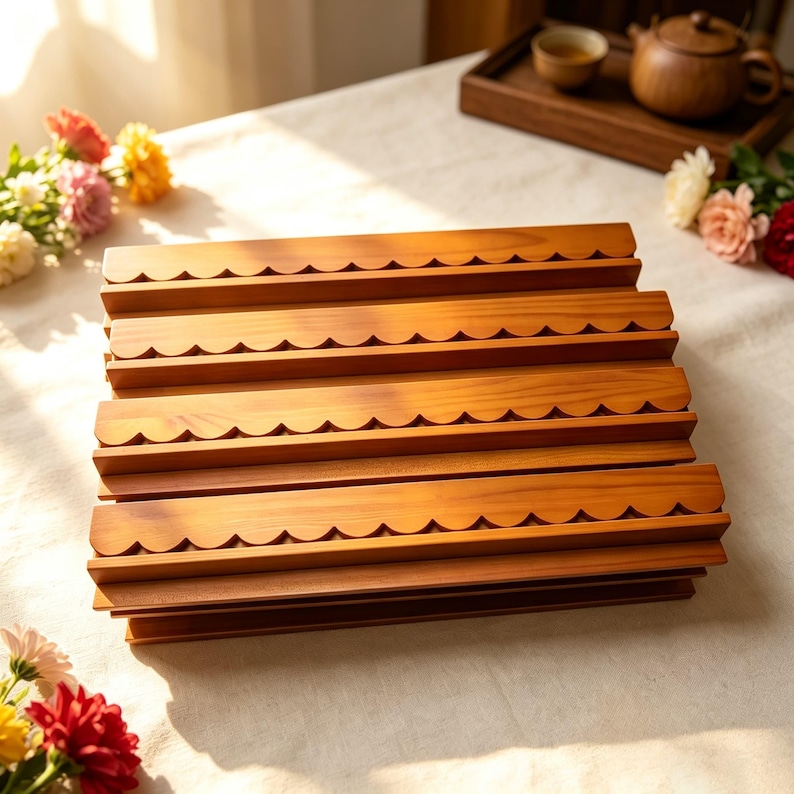 May include: A rectangular wooden display rack featuring four horizontal tiers, each with a decorative scalloped edge. The light brown wood grain is visible across the tiered structure, which is designed to hold items in a stacked, organized arrangement.