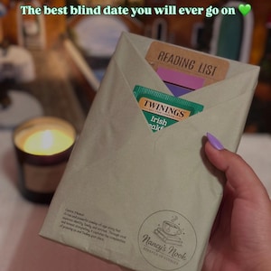 May include: A wrapped book with a "Reading List" sticker and a Twinings Irish Breakfast tea bag peeking out. The package is sealed with a "Nancy's Nook" sticker. Text on the package reads "The best blind date you will ever go on."