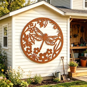 Può includere: Una grande opera d'arte murale circolare in metallo marrone arrugginito con un design di libellula e fiori. La libellula è posizionata centralmente, circondata da fiori e foglie. L'opera è montata su una parete bianca a doghe orizzontali.