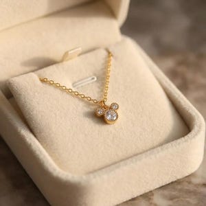 Auralis signature jewelry box presenting a dainty 18K gold plated crystal necklace, designed to be stored away from moisture and chemicals.