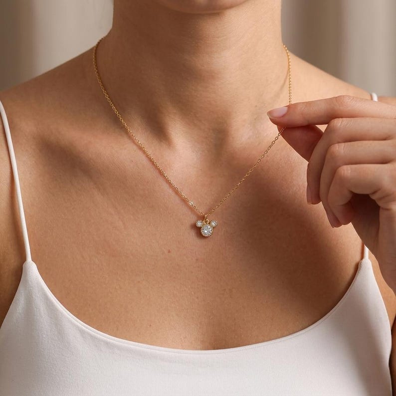 Minimalist silver plated brass mouse ear necklace featuring tiny clear stones, elegant small-scale everyday jewelry.