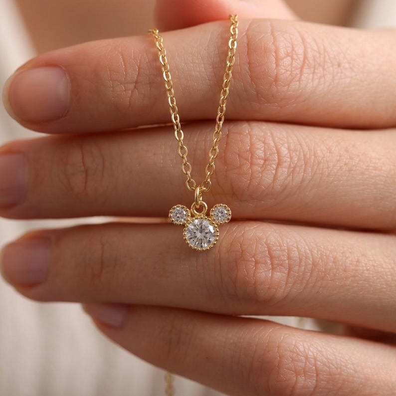Close-up of a small-scale 18K gold plated crystal pendant showing delicate beaded setting, minimalist everyday necklace.