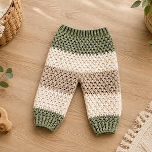 Puede incluir: Pantalones de ganchillo con un patrón de rayas en bandas alternas de color verde oliva, crema y marrón claro. La prenda tiene una cintura acanalada y puños acanalados en los tobillos, confeccionada con un diseño de punto de ganchillo texturizado.