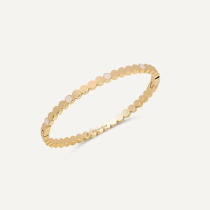 Op de afbeelding: Goudkleurige armband met een herhalend patroon van kleine, cirkelvormige vormen. De armband heeft een sluiting en is gegraveerd met "VIVA LA BELLE". Een delicaat sieraad.
