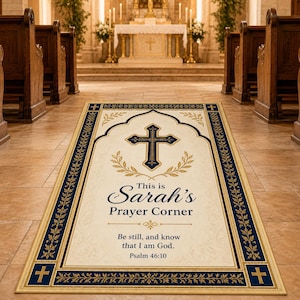 Puede incluir: Una alfombra de oración rectangular con un centro color crema y un borde azul marino. La alfombra presenta una cruz, el texto "This is Sarah's Prayer Corner" y un versículo bíblico. La alfombra está colocada en un pasillo de la iglesia.