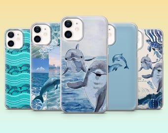May include: Five iPhone cases with dolphin designs. The cases feature various shades of blue and white, with illustrations of dolphins swimming in the ocean. The cases have a glossy finish and are arranged in a row against a gradient background.